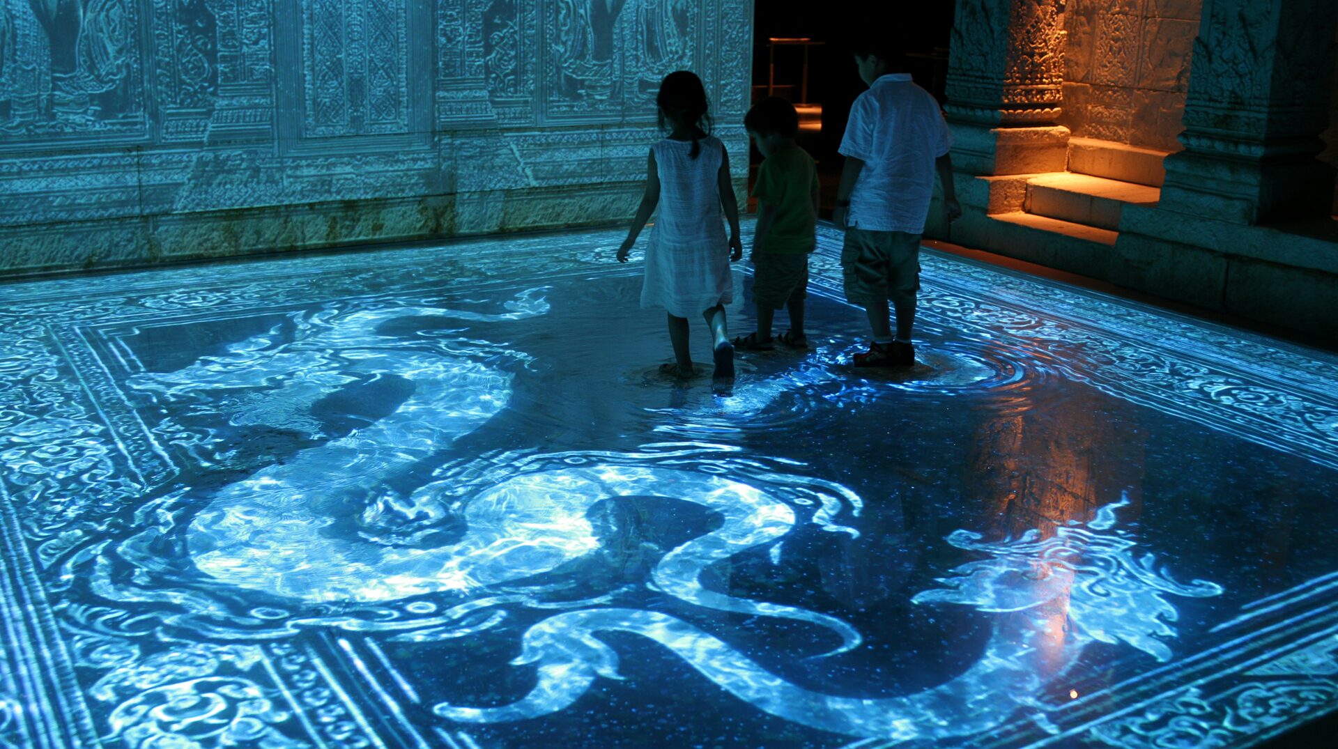 children interacting with a glowing naga serpent on a mirror floor inside 4AM Bangkok